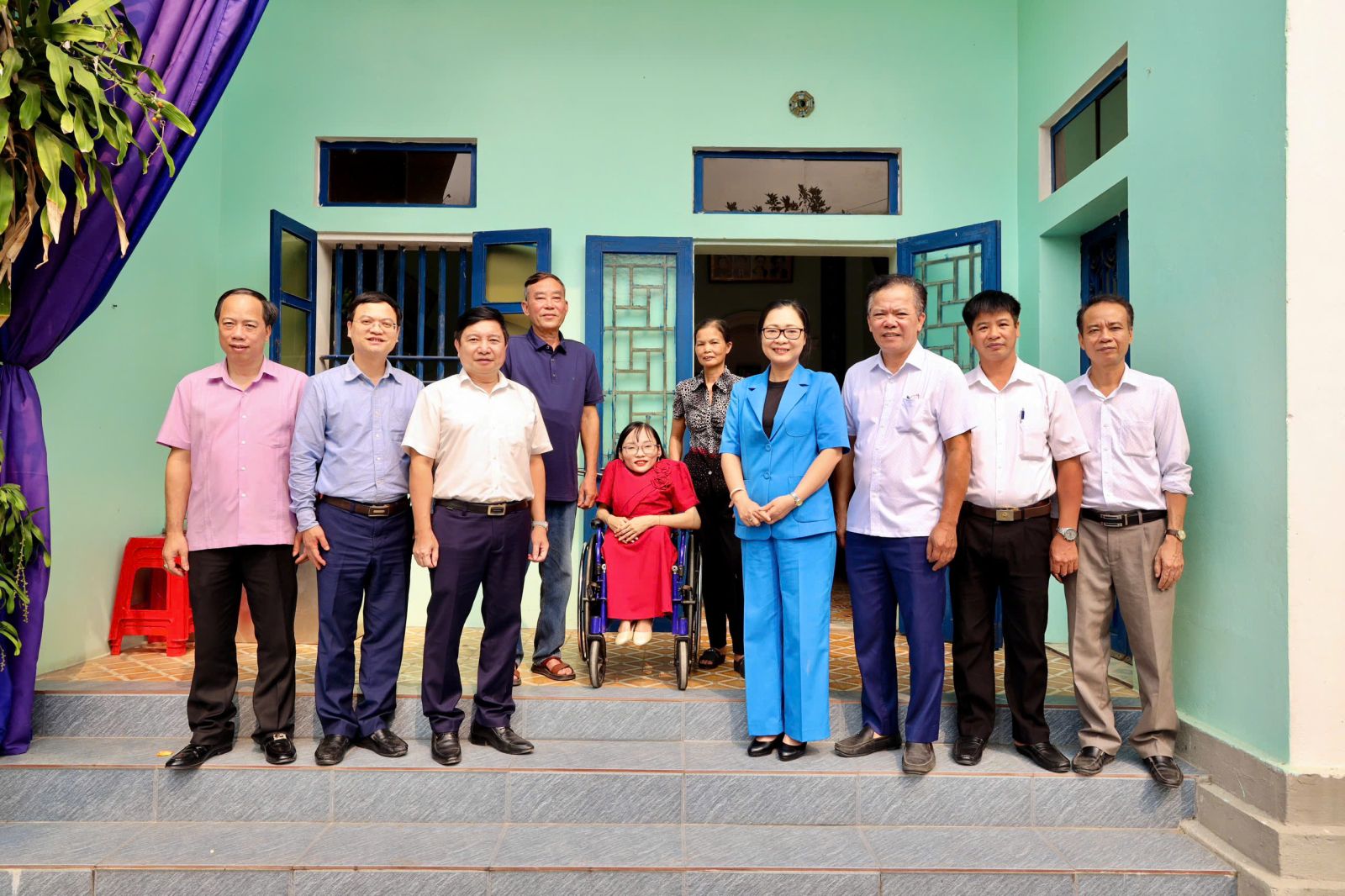 A group of people standing in front of a building Description automatically generated