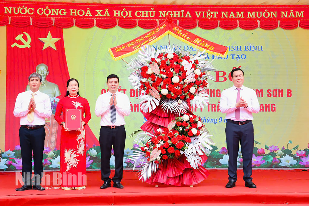 Đồng chí Trần Đăng Quỳnh, Ủy viên dự khuyết Trung ương Đảng, Phó Bí thư Thường trực Tỉnh ủy trao Quyết định và tặng hoa chúc mừng nhà trường.