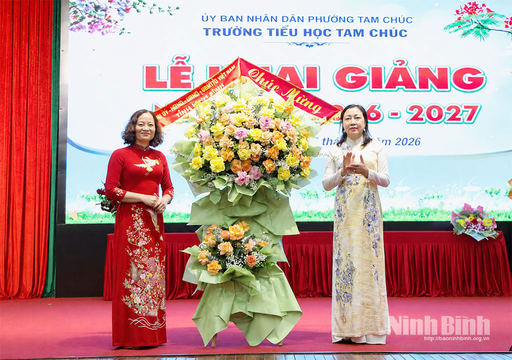 Đồng chí Đinh Thị Lụa, Phó Bí thư Tỉnh ủy, Chủ tịch Ủy ban MTTQ Việt Nam tỉnh tặng hoa chúc mừng nhà trường.
